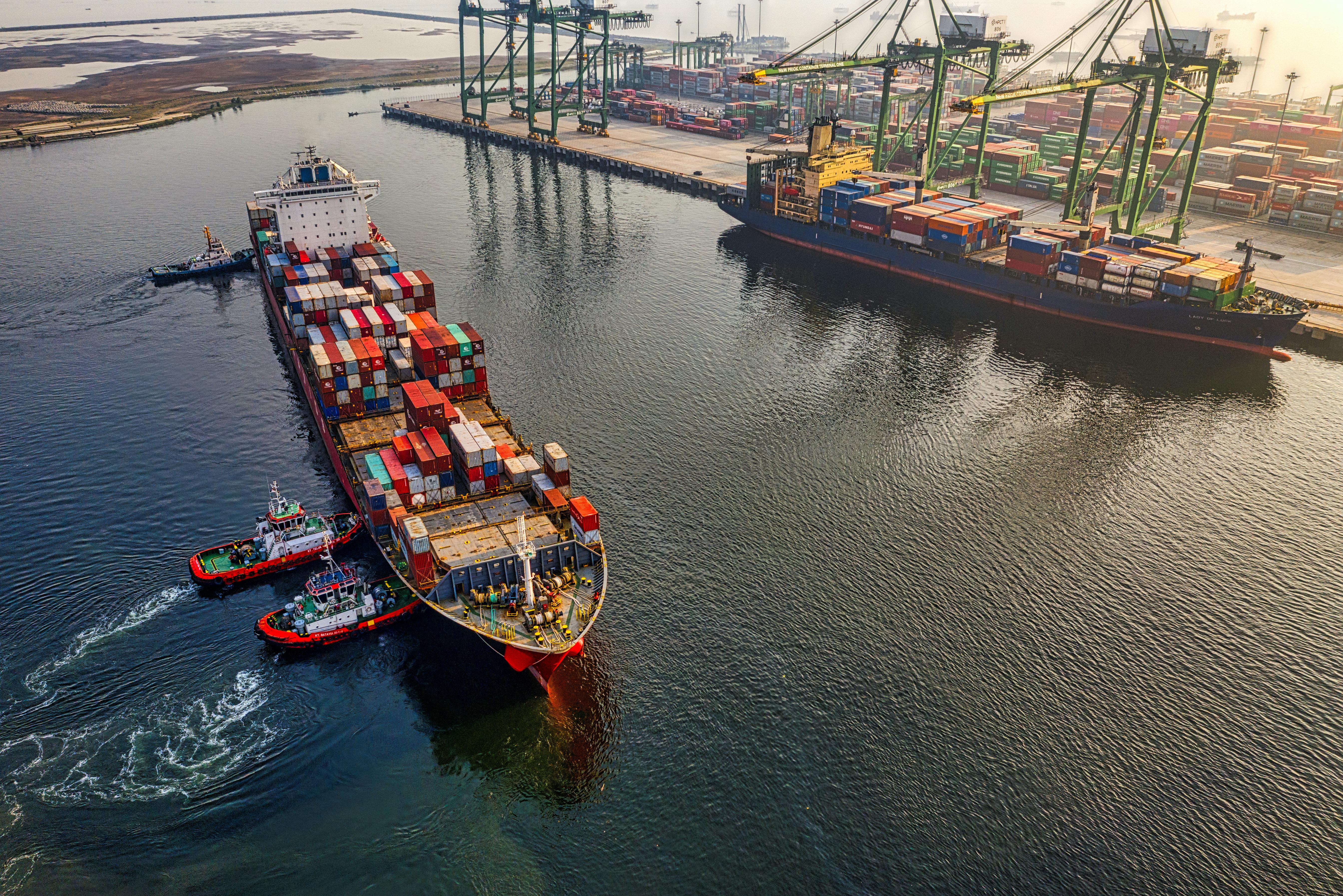 Container ship with tugs at port